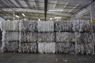 Bundles of flattened plastic products stacked on one another ready to be processed in a recycling center in India