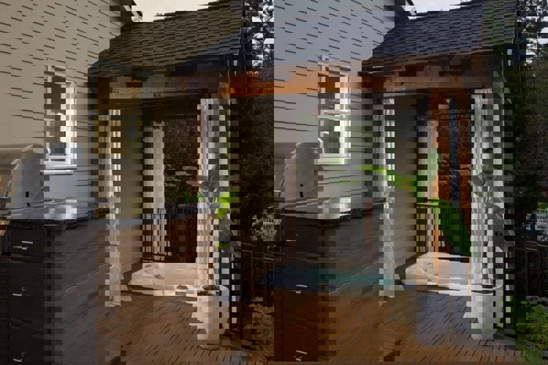 Patio with a hottub inclosed by a pergola