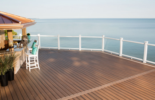 Glass railings overlooking the ocean on a brown composite deck.