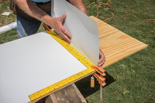 Bend flashing with a block and framing square for a 90 degree bend to fit inside the house corner wall.