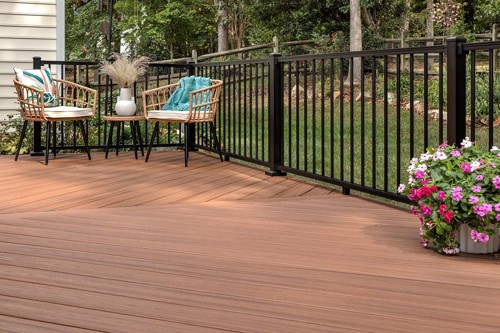 Sleek black aluminum deck rail sitting on a brown composite Trex deck.